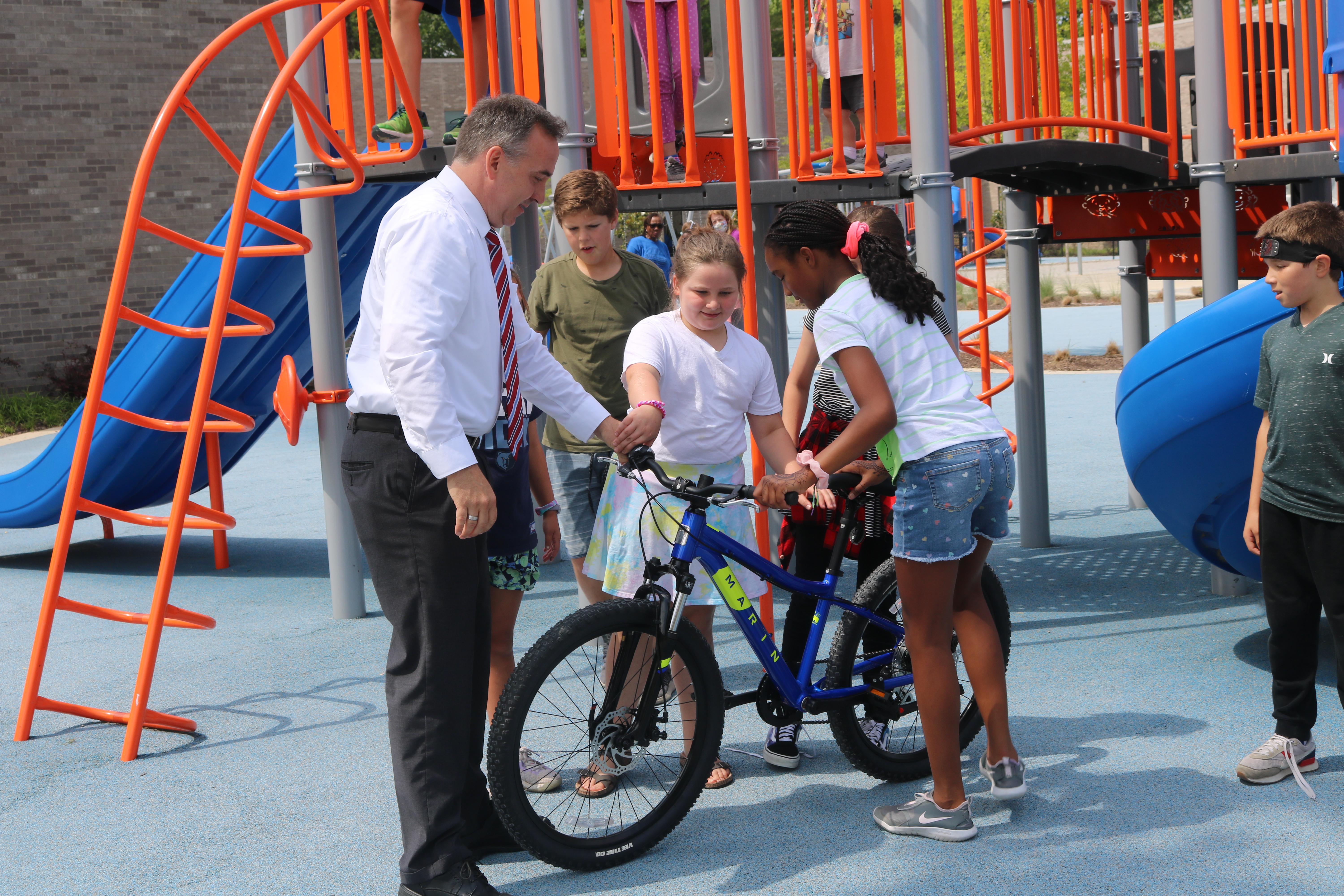 Mr. Manuel with children on a bike